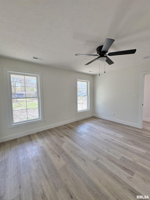 209 Madison St, Cambria, IL 62915 - empty room featuring light wood-type flooring, baseboards, a ceiling fan, and a textured ceiling