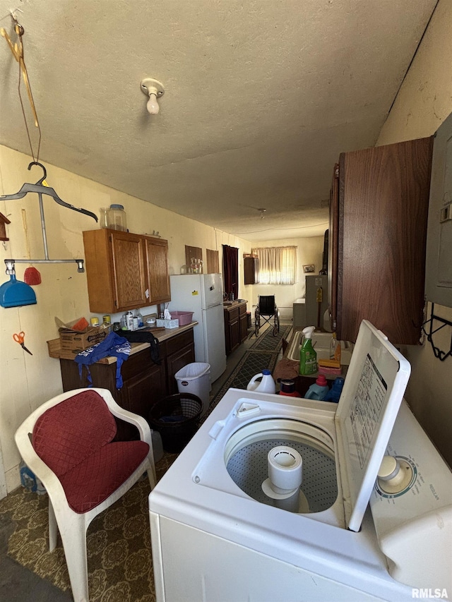 laundry area featuring laundry area, a textured ceiling, and washer / clothes dryer