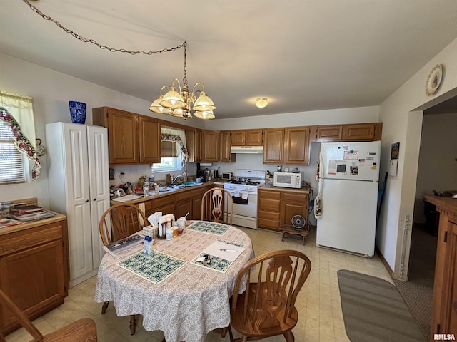 kitchen featuring a notable chandelier, under cabinet range hood, white appliances, brown cabinetry, and light floors