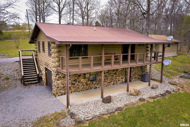 320 Nelson Ln, Grantsburg, IL 62943 - rear view of property with stairway, a patio, stone siding, metal roof, and log exterior
