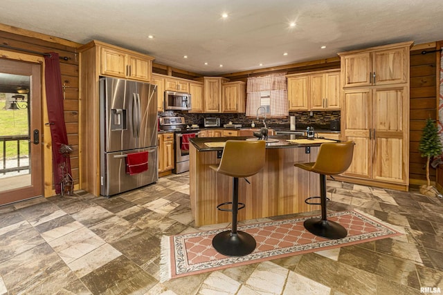320 Nelson Ln, Grantsburg, IL 62943 - kitchen featuring stone tile floors, dark countertops, appliances with stainless steel finishes, and an island with sink