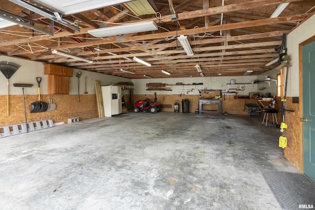 320 Nelson Ln, Grantsburg, IL 62943 - garage with white refrigerator with ice dispenser and a workshop area