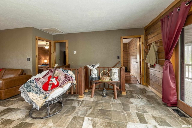 320 Nelson Ln, Grantsburg, IL 62943 - living room with stone finish floor, visible vents, wooden walls, and a textured ceiling