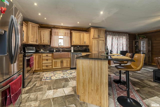 320 Nelson Ln, Grantsburg, IL 62943 - kitchen featuring stainless steel appliances, dark countertops, a kitchen island, a sink, and a breakfast bar area