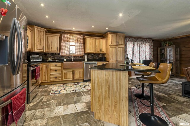 320 Nelson Ln, Grantsburg, IL 62943 - kitchen featuring dark countertops, appliances with stainless steel finishes, a sink, a breakfast bar area, and a center island