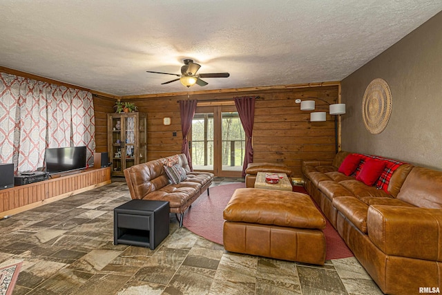 320 Nelson Ln, Grantsburg, IL 62943 - living area featuring a textured ceiling, wooden walls, stone finish floor, and a ceiling fan