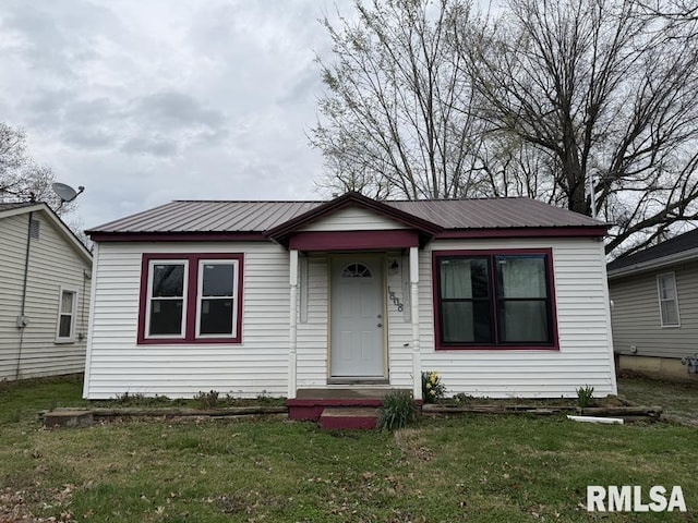 bungalow-style house with a front lawn and metal roof