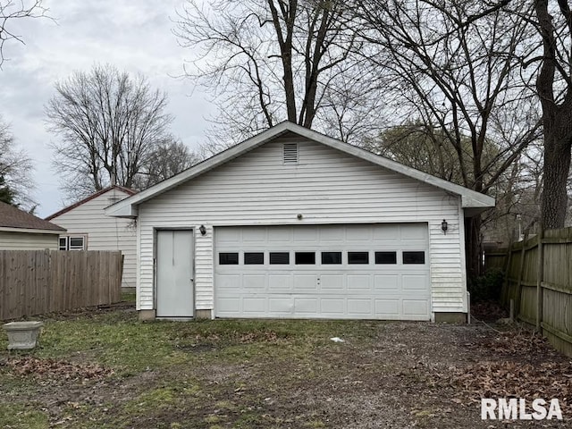 detached garage featuring fence