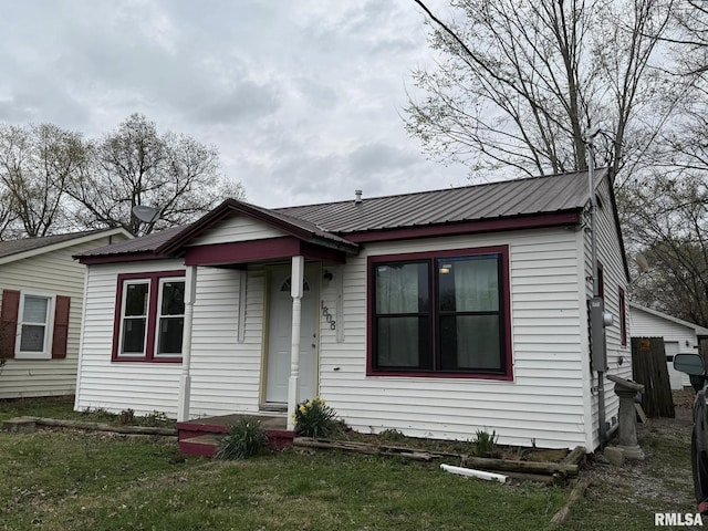 bungalow-style home featuring metal roof and a front yard