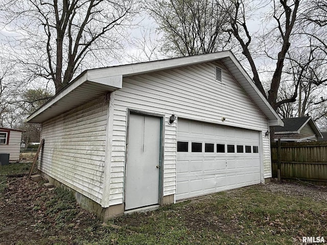 detached garage featuring fence