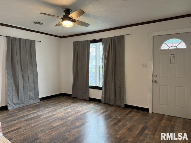 foyer entrance with visible vents, crown molding, plenty of natural light, a ceiling fan, and dark wood-type flooring
