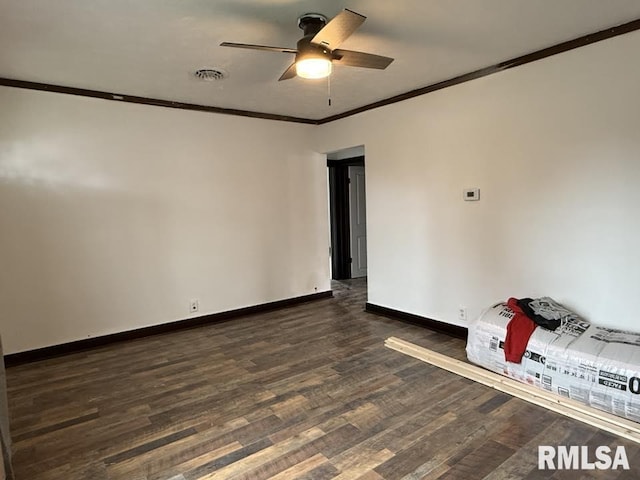 spare room featuring visible vents, crown molding, baseboards, ceiling fan, and dark wood-type flooring