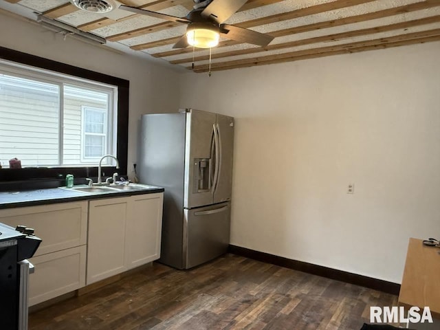 kitchen with stainless steel refrigerator with ice dispenser, electric stove, a sink, dark countertops, and dark wood-style floors