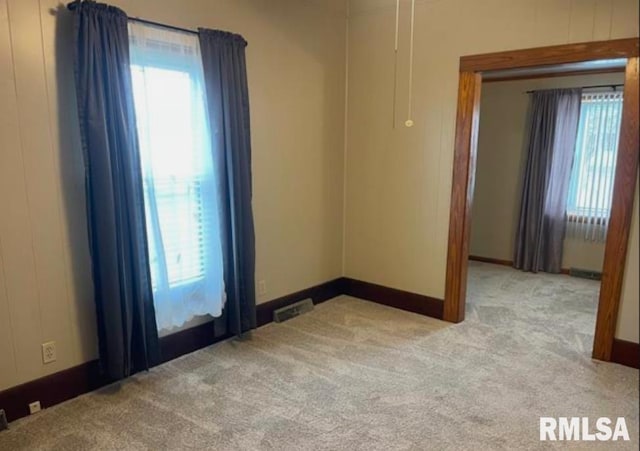 unfurnished room with carpet floors and visible vents
