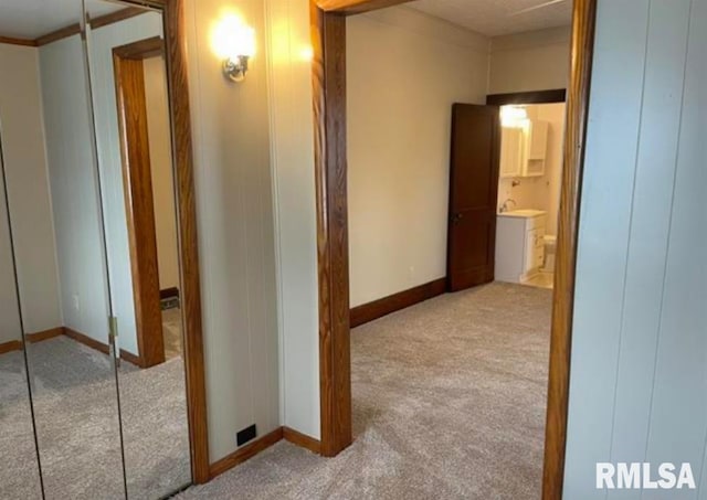 hall with baseboards and carpet