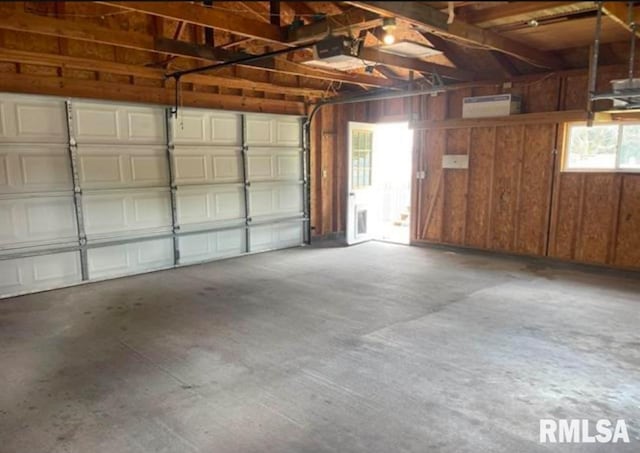 garage featuring wood walls and a garage door opener