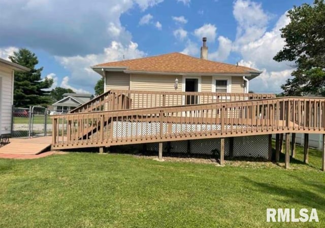 back of house with a deck and a yard