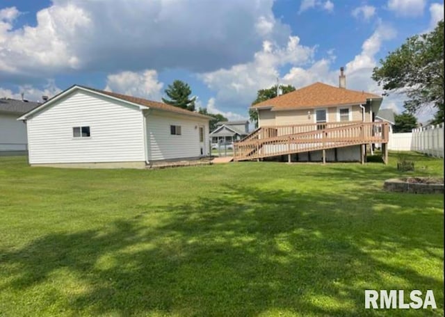 rear view of property featuring fence, a deck, and a yard