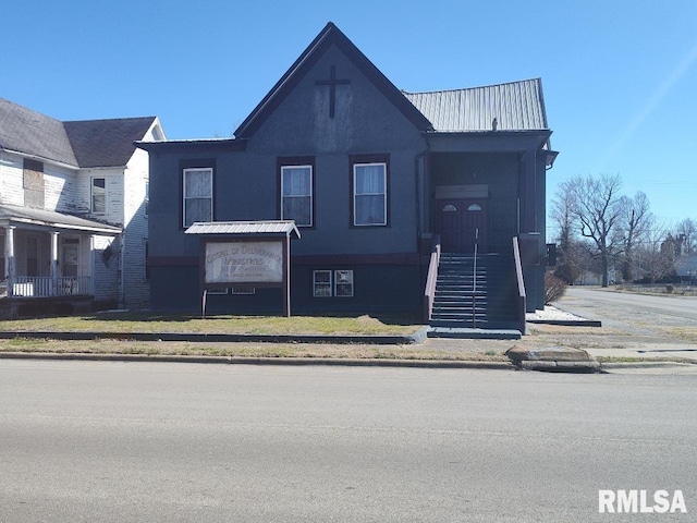 view of front facade with stucco siding and metal roof