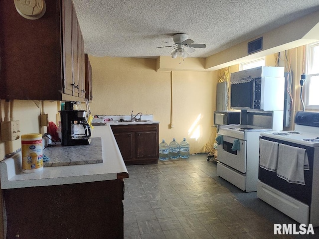 kitchen with black microwave, white electric range, ceiling fan, and a sink