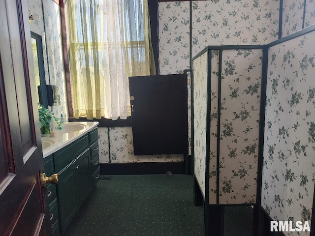 full bath with wallpapered walls, vanity, and a shower stall