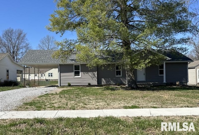 view of front of home with a front yard, an attached carport, and driveway