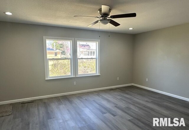 unfurnished room with visible vents, baseboards, recessed lighting, a ceiling fan, and dark wood-style floors