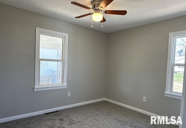 spare room with carpet flooring, baseboards, ceiling fan, and visible vents
