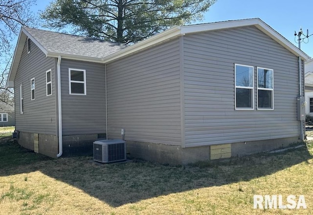 view of property exterior with a shingled roof, crawl space, cooling unit, and a yard
