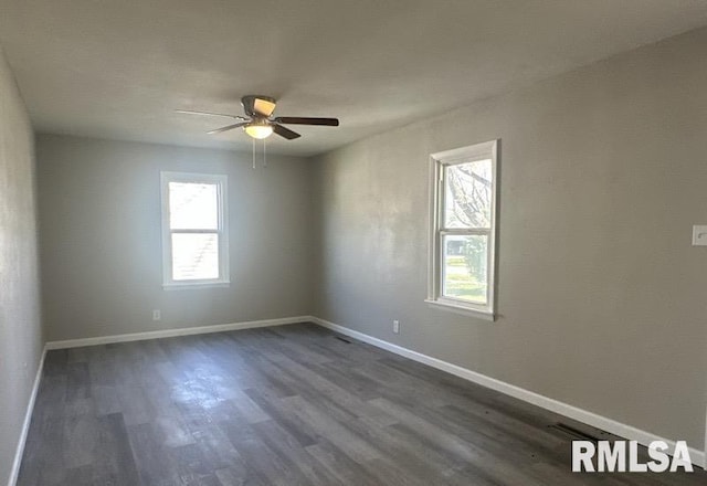 empty room with a ceiling fan, dark wood-style floors, and baseboards