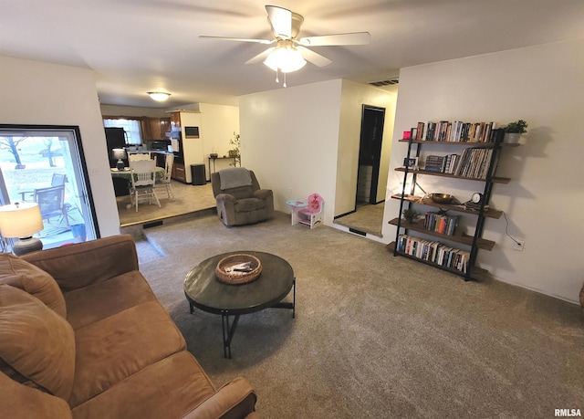 carpeted living room featuring visible vents and ceiling fan