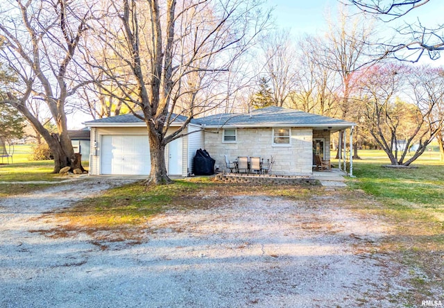 exterior space featuring driveway, an attached garage, and a yard