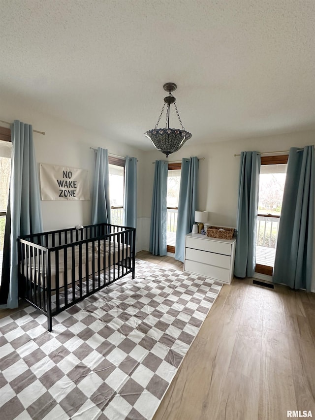 701 Rachael Ct, Carterville, IL 62918 - bedroom with wood finished floors, multiple windows, and a textured ceiling