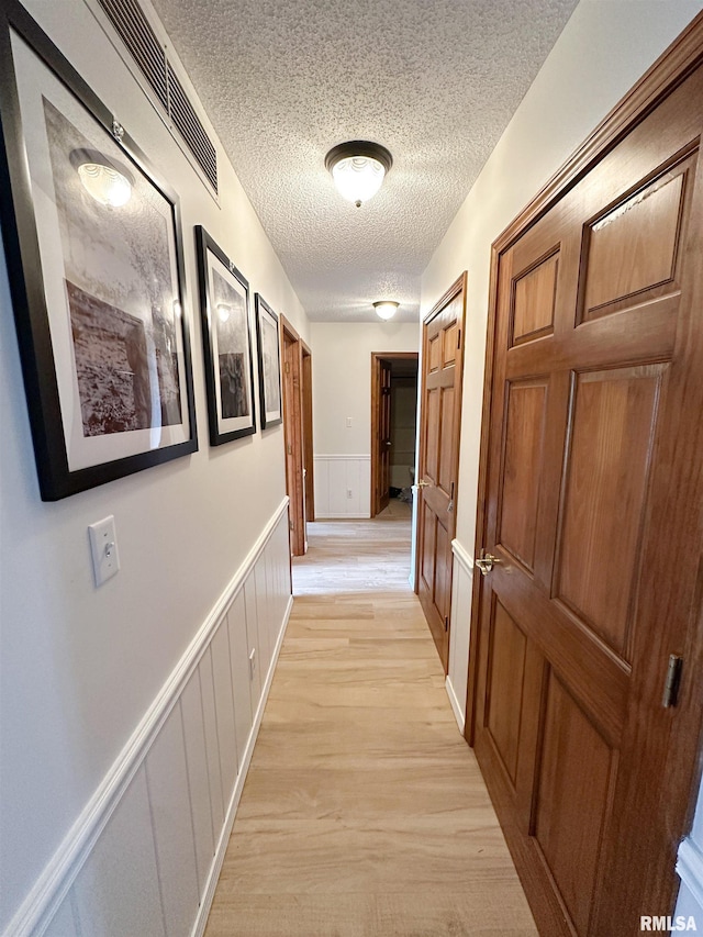 701 Rachael Ct, Carterville, IL 62918 - corridor with wainscoting, light wood-style floors, and a textured ceiling