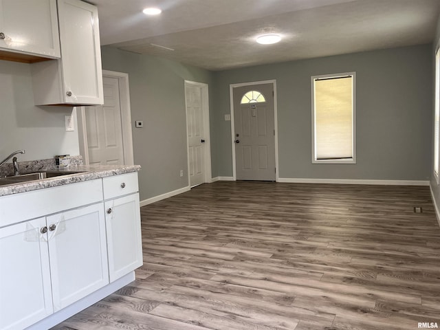 421 N 18th St, Herrin, IL 62948 - kitchen featuring baseboards, white cabinets, wood finished floors, and a sink