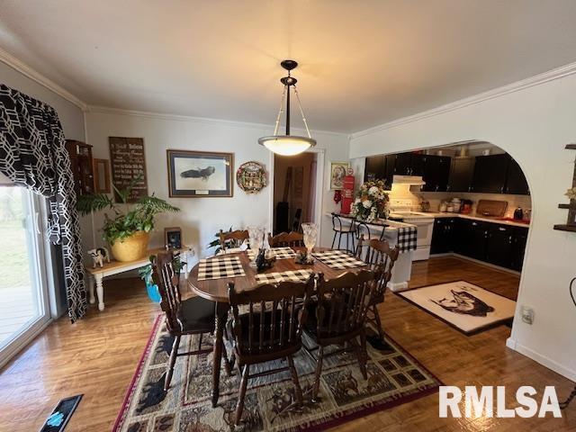 188 W Honeysuckle Dr, Elizabethtown, IL 62931 - dining area featuring arched walkways, crown molding, and wood finished floors