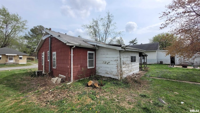 view of side of property featuring central air condition unit and a lawn