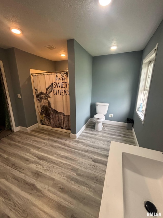 17116 Old Town Dr, Sesser, IL 62884 - interior space featuring a shower with curtain, toilet, visible vents, baseboards, and wood finished floors