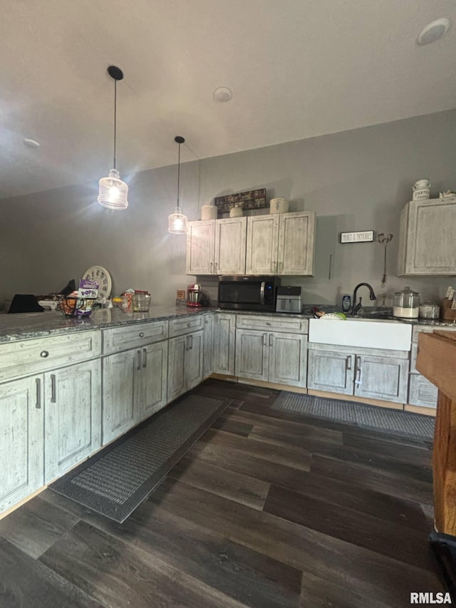 17116 Old Town Dr, Sesser, IL 62884 - kitchen with dark wood-style floors, dark countertops, a sink, stainless steel microwave, and hanging light fixtures