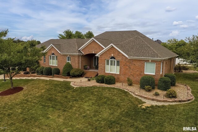 single story home with a front yard, brick siding, and roof with shingles