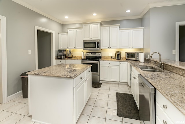 kitchen featuring light tile patterned flooring, a sink, ornamental molding, and appliances with stainless steel finishes