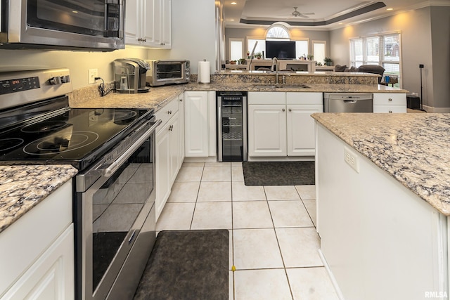 kitchen featuring a sink, light tile patterned floors, appliances with stainless steel finishes, and wine cooler