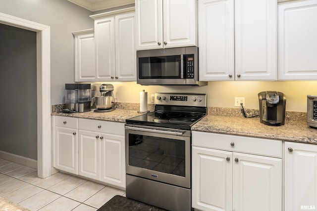 kitchen with light stone counters, light tile patterned floors, white cabinets, and stainless steel appliances