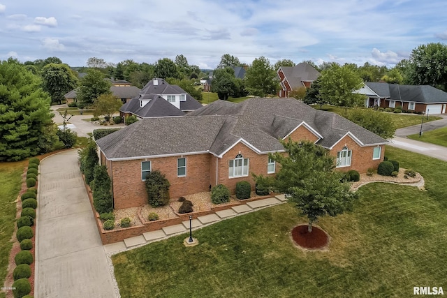 view of front of home with roof with shingles, a residential view, a front lawn, and brick siding