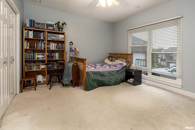bedroom with a closet, ceiling fan, carpet flooring, and visible vents