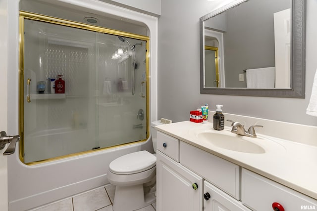 bathroom with combined bath / shower with glass door, toilet, tile patterned flooring, and vanity