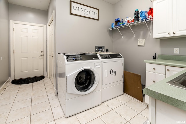 laundry area with cabinet space, light tile patterned floors, and separate washer and dryer