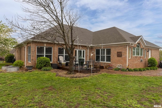 back of house with a yard, brick siding, and a deck