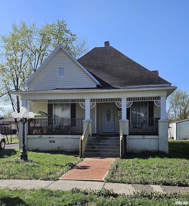 107 W Lincoln St, Harrisburg, IL 62946 - view of front facade featuring a shingled roof, covered porch, a front yard, and a chimney
