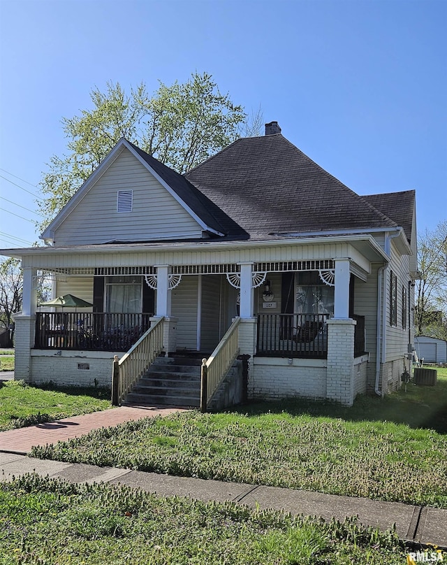 107 W Lincoln St, Harrisburg, IL 62946 - view of front of property featuring a porch, roof with shingles, a chimney, and a front yard